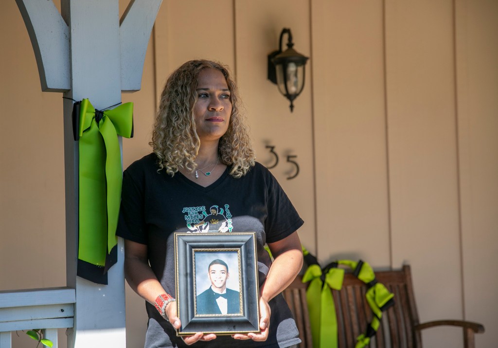 Taun Hall stands on the porch of her Walnut Creek home next to a green ribbon, the international symbol for mental health awareness. She and some of her neighbors display the ribbons in remembrance of her son, Miles, who was killed last year by Walnut Creek police during a mental health crisis. Photo by Anne Wernikoff for CalMatters
