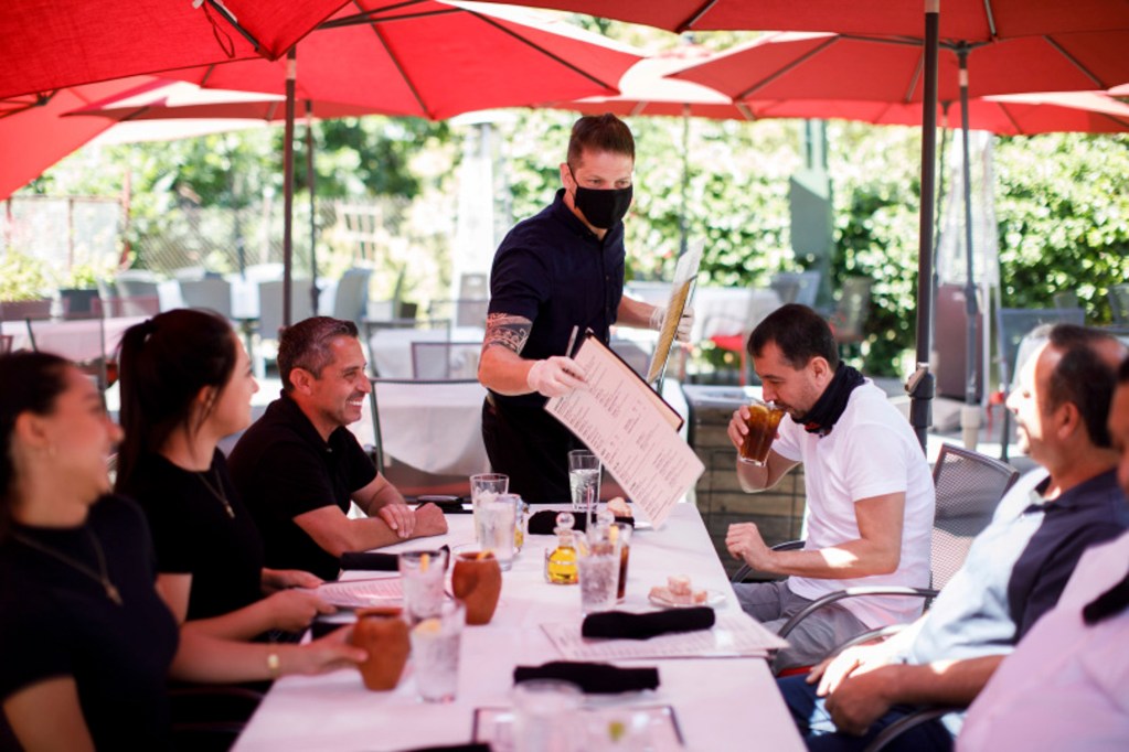 Cleverson Davis, a waiter at Palermo Italian Restaurant in San Jose tends to customers while wearing a mask on June 5, 2020. Photo by Dai Sugano, Bay Area News Group