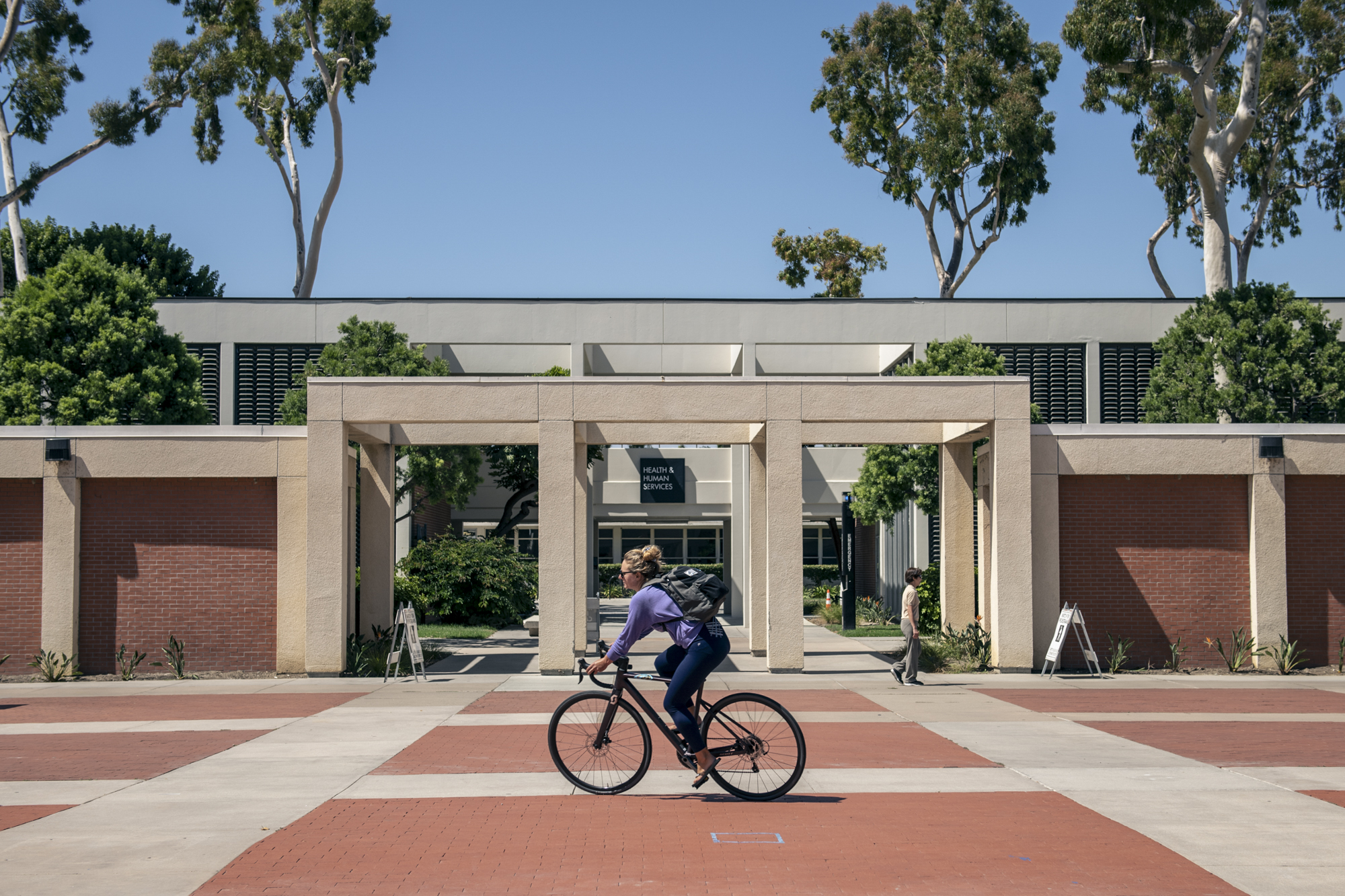 A cyclist rides through campus at Cal State Long Beach in Long Beach on July 25, 2022. Photo by Pablo Unzueta for CalMatters