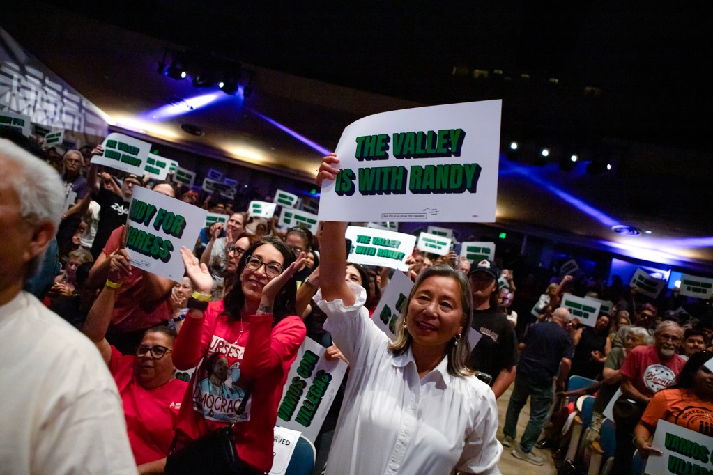 Supporters cheer and hold green-and-white campaign signs at a crowded political rally, including one reading, “The Valley is with Randy.”
